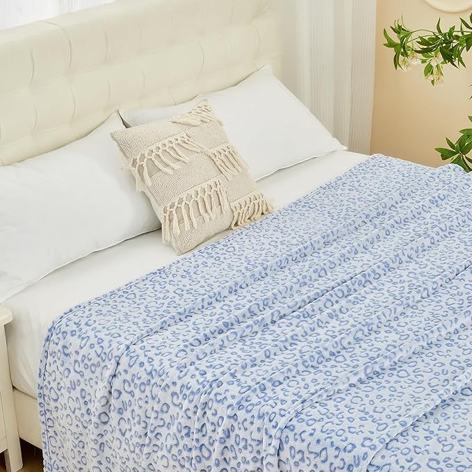 Shopi Vella super soft women's blanket in light blue leopard print on white bed with decorative pillow