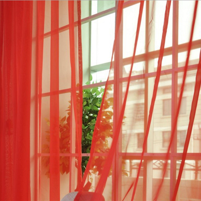 Shopi Vella red transparent tulle window curtains hanging over window with green plant outside