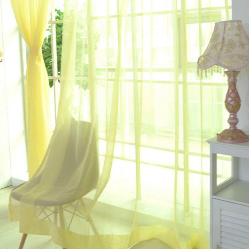 Shopi Vella transparent tulle window curtains softly draped over a chair in a sunlit room