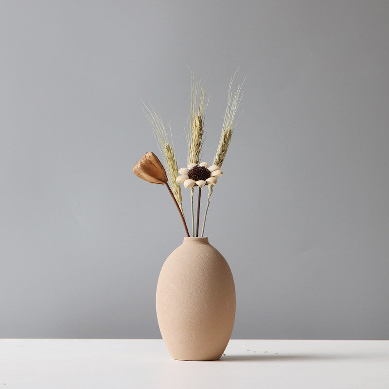 Minimalist beige vase with dried flowers and wheat on a TV cabinet flower stand for home storage