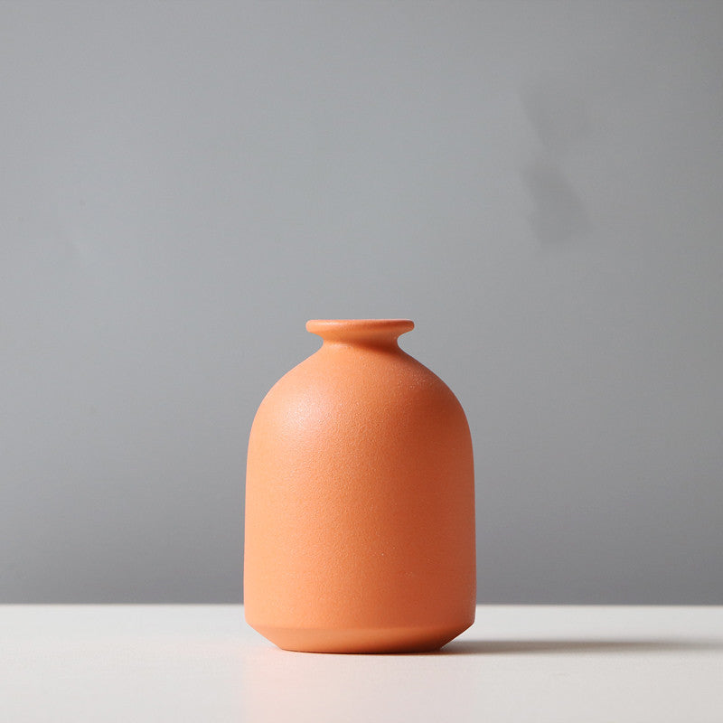 Minimalist orange ceramic vase on a TV cabinet flower stand by Shopi Vella for home storage