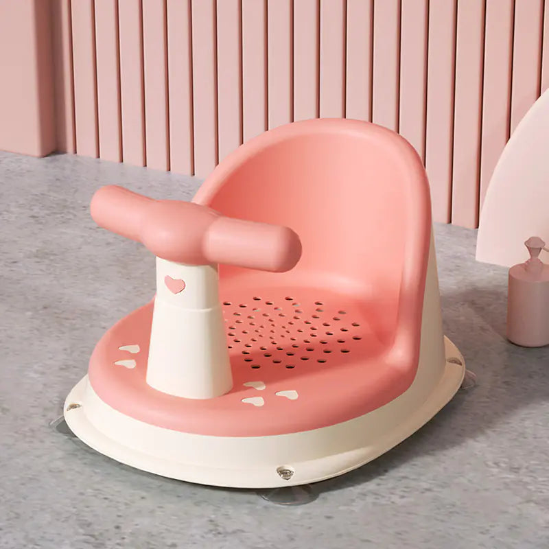 Pink and white universal baby bath seat with splash guard and heart design on gray floor