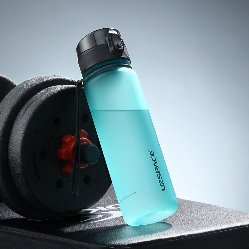 Shopi Vella colorful sports water bottle in blue with black cap placed on gym equipment