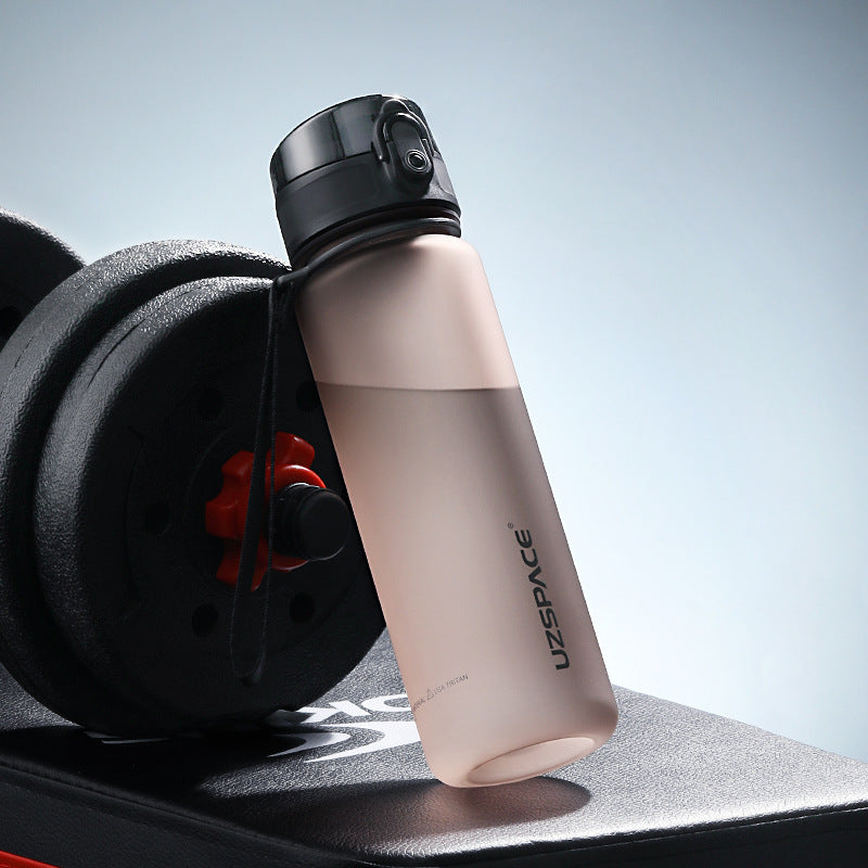 Shopi Vella colorful sports water bottle leaning on black dumbbell for gym hydration