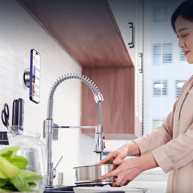 Shopi Vella vacuum adsorption phone holder mounted on kitchen wall holding phone near woman cooking