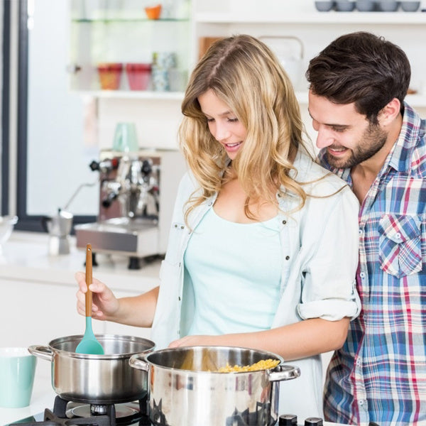 Couple cooking together using a 35 piece kitchen utensil set in a modern kitchen setup