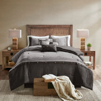 Shopi Vella 7 piece faux suede comforter set in dark gray on queen bed with matching pillows and wooden headboard