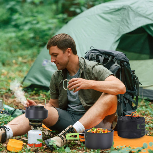 Man camping using campfire cookware set for hiking with tent and backpack in forest