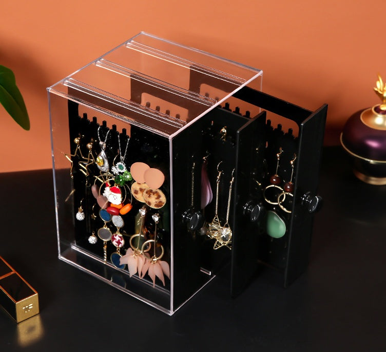 Clear makeup storage box with drawers and black panels for organizing earrings and jewelry