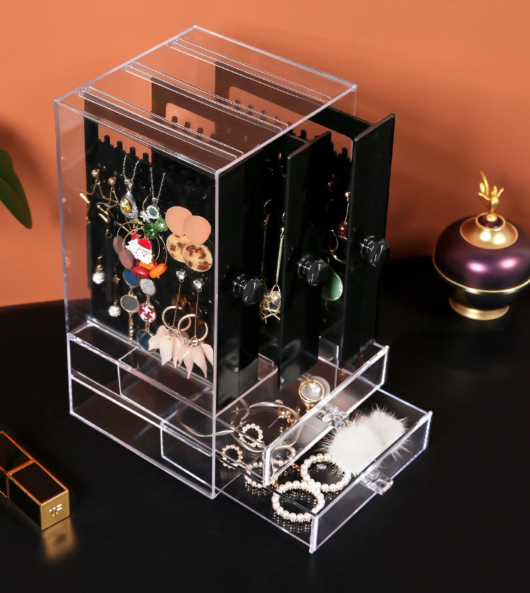 Shopi Vella clear makeup storage box with drawers organizing earrings and accessories on black surface