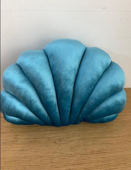 Shopi Vella cute shell nap pillow for kids in soft blue velvet fabric on wooden surface