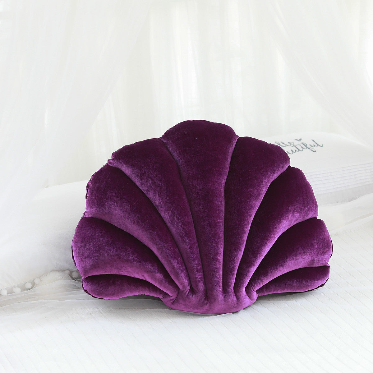 Shopi Vella purple cute shell nap pillow for kids shaped like a seashell on white bed