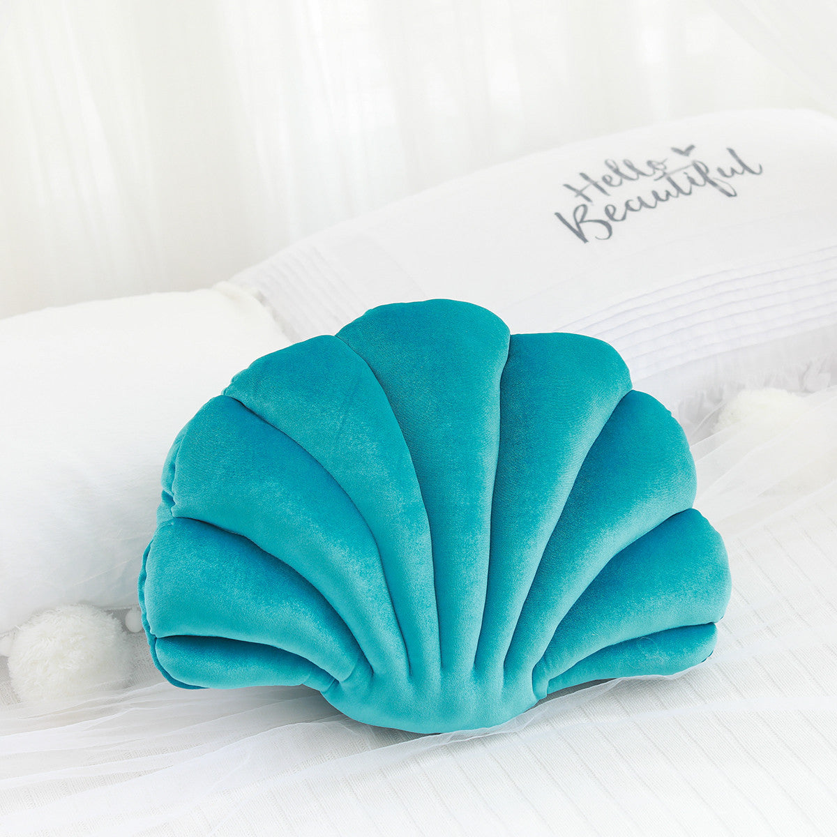 Shopi Vella cute shell nap pillow for kids in turquoise blue velvet on white bedding
