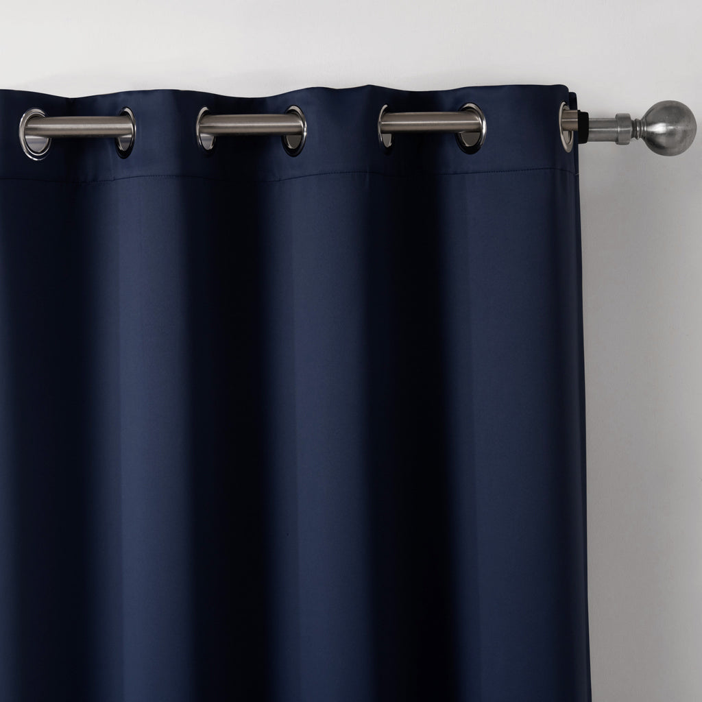 Shopi Vella dark blue blackout curtains with metal grommets hanging on a silver curtain rod