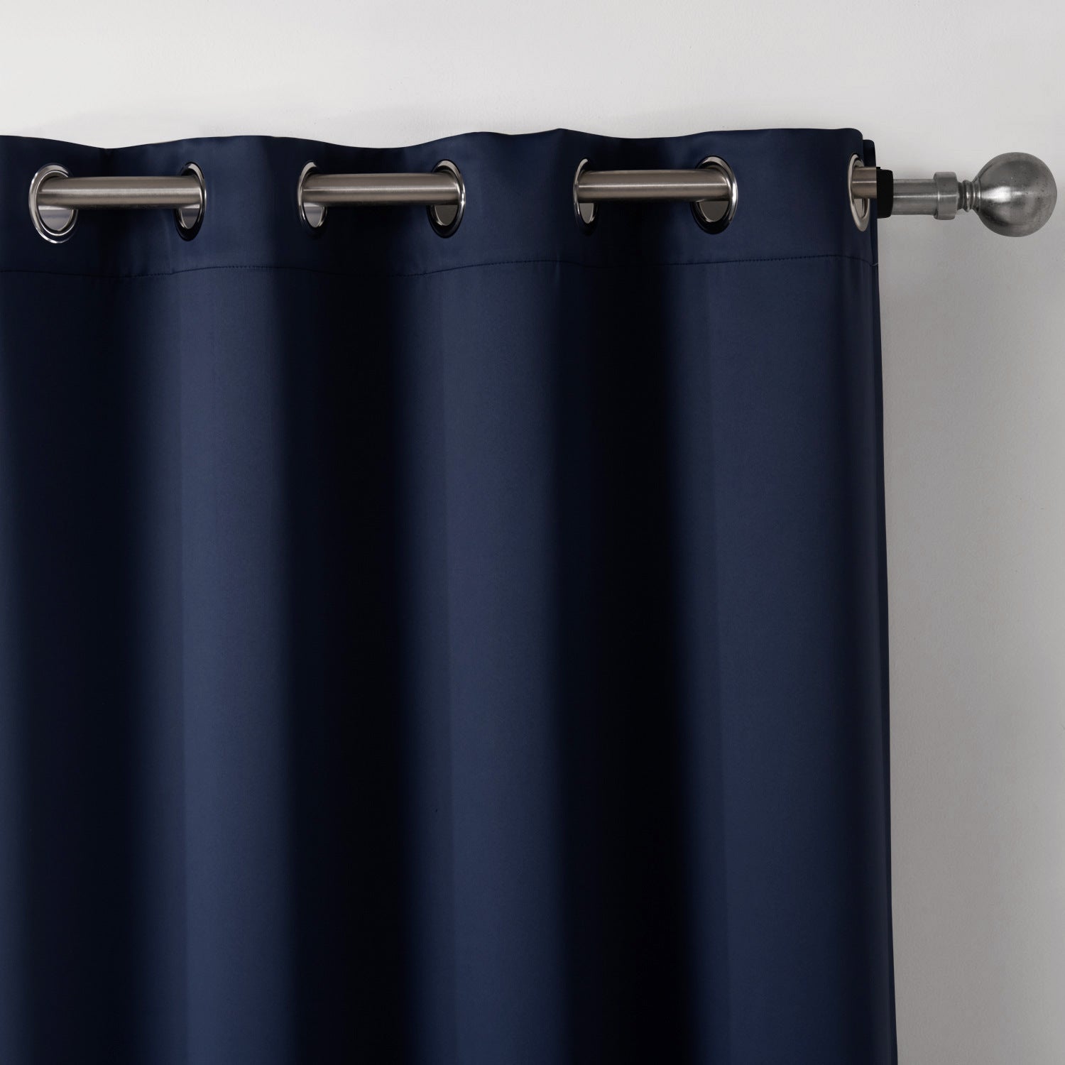 Shopi Vella dark blue blackout curtains with metal grommets hanging on a silver curtain rod