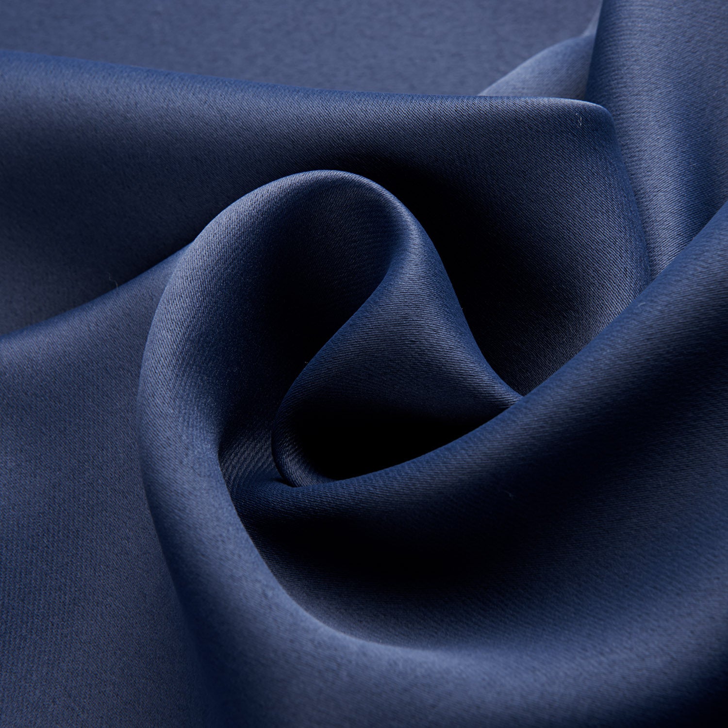 Close-up of smooth dark blue blackout curtains fabric with elegant texture and deep color
