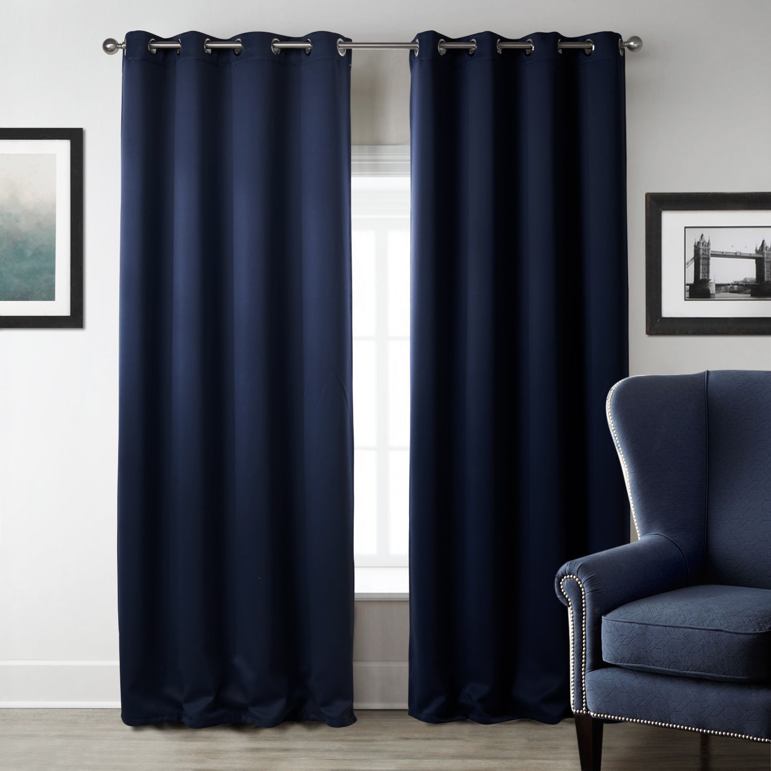 Shopi Vella dark blue blackout curtains hanging in a modern living room with blue armchair and framed wall art