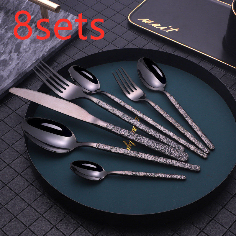 Shopi Vella black patterned cutlery set displayed on a dark plate for elegant dining