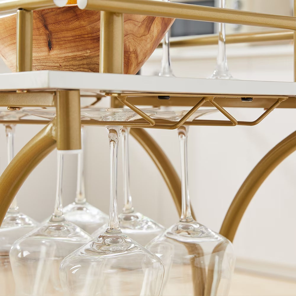 Close-up of modern bar trolley for home with gold frame and hanging wine glasses