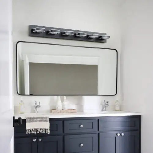 Modern black bathroom vanity light with five horizontal fixtures mounted above a rectangular mirror in a stylish bathroom
