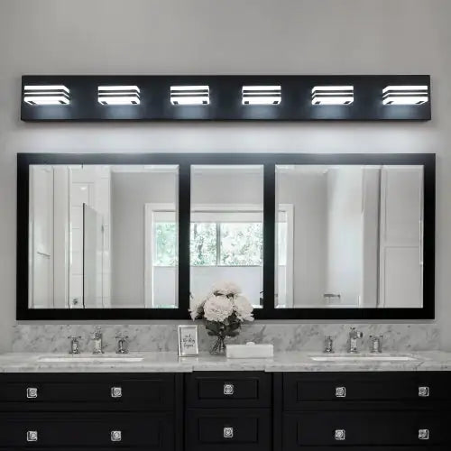 Modern black bathroom vanity light with six illuminated LED fixtures mounted above a triple mirror