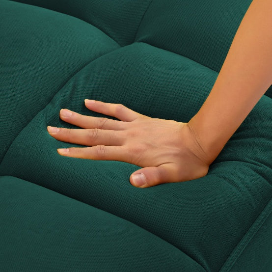 Hand pressing cushioned seat of modern fabric sofa for living room by Shopi Vella in dark green