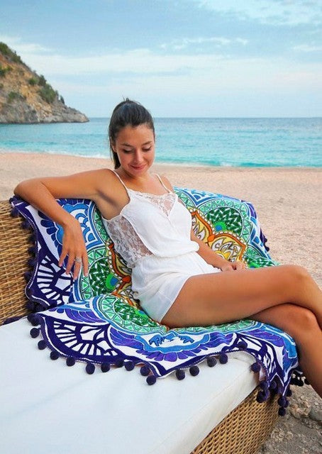 Woman relaxing on a wicker chair by the beach with a colorful polygon yoga mat round as a cover