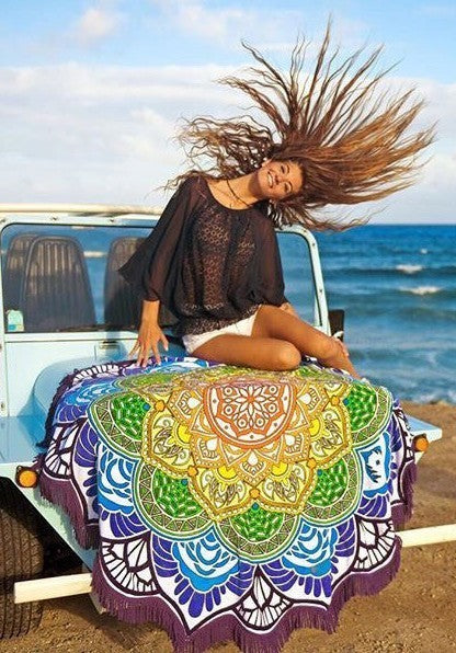 Polygon yoga mat round with colorful mandala design displayed on a beach jeep with a woman sitting