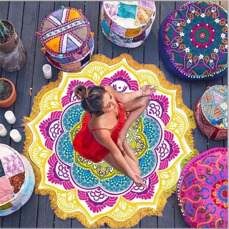 Woman meditating on colorful polygon yoga mat round surrounded by vibrant embroidered cushions
