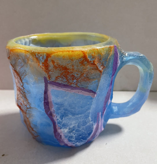Colorful Shopi Vella resin crystal coffee mug with blue, orange, and purple abstract design