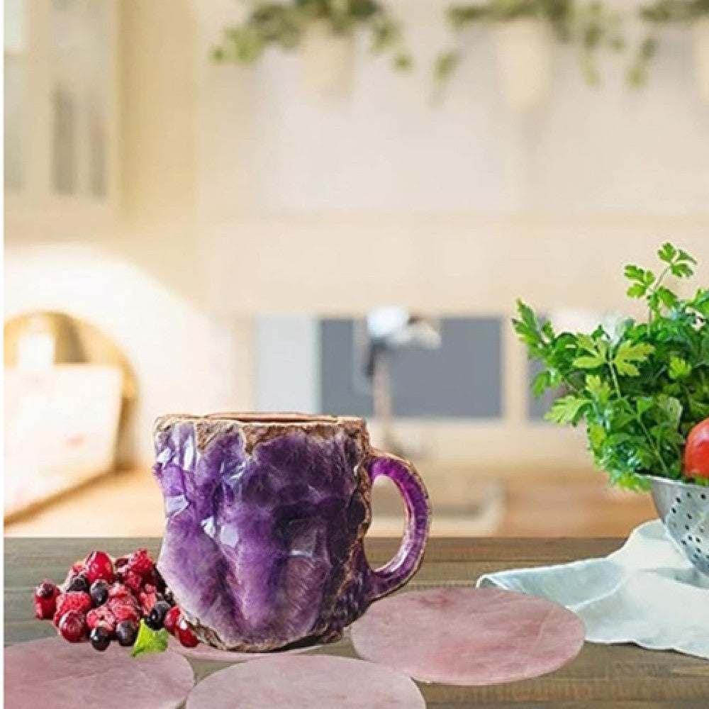 Purple resin crystal coffee mug with textured surface placed on wooden kitchen table next to berries and greenery