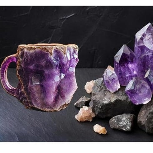Purple resin crystal coffee mug with rough textured design on dark surface beside matching crystal stones