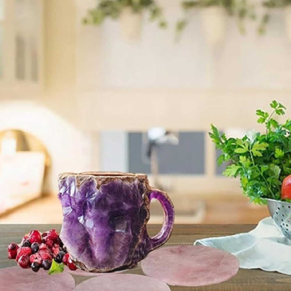 Purple resin crystal coffee mug with textured surface placed on a kitchen table next to berries and greens