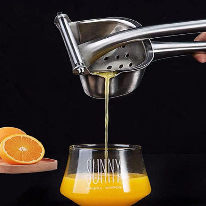 Shopi Vella stainless steel manual juicer extracting fresh juice into a glass with orange slices nearby