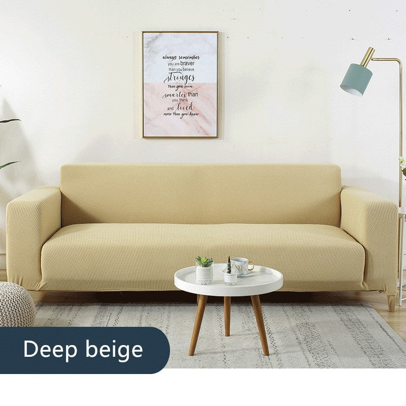 Deep beige waterproof sofa slipcover on a modern sofa in a minimalist living room setup