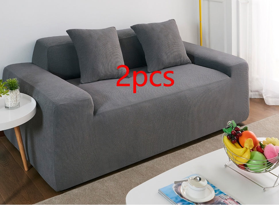 Shopi Vella waterproof sofa slipcover in dark gray covering a modern two-seater sofa with matching cushions
