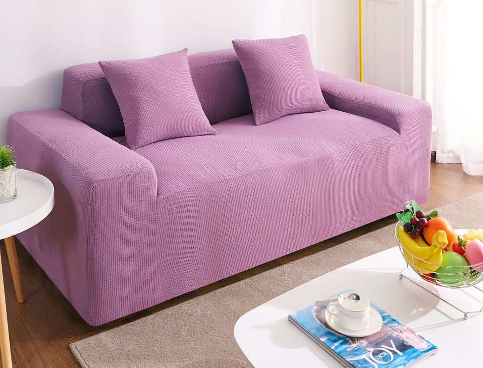 Shopi Vella waterproof sofa slipcover in light purple covering a three-seat sofa with matching pillows in living room