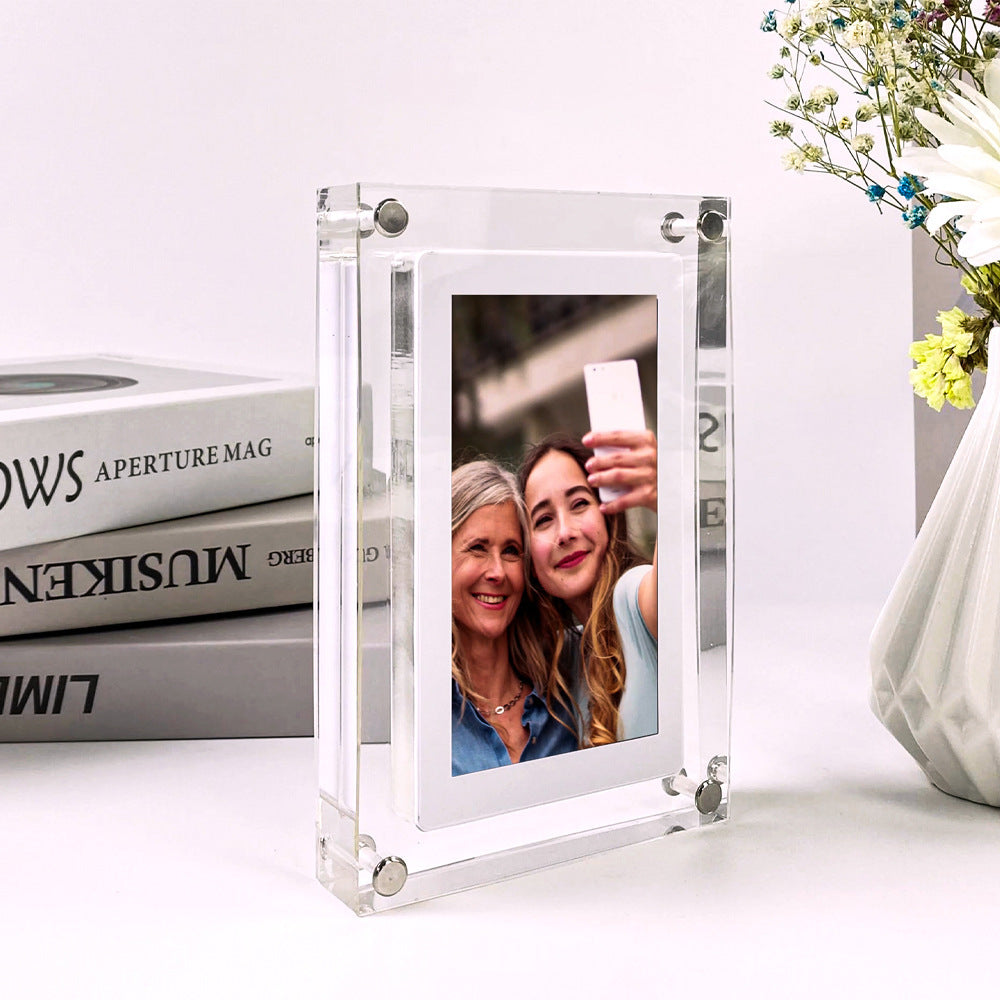 Shopi Vella vertical digital photo frame with battery displaying two women taking a selfie on a white table