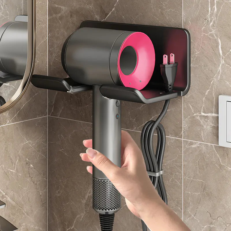 Wall mounted bathroom hair dryer rack holding a modern gray and pink hair dryer on marble wall