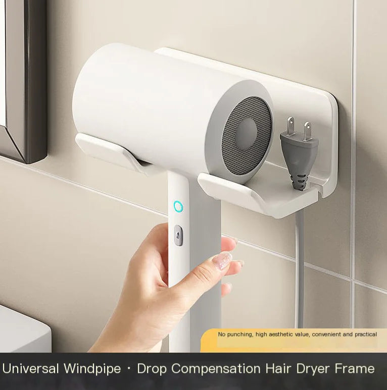 White wall mounted bathroom hair dryer rack holding a white hair dryer and plug on tiled wall