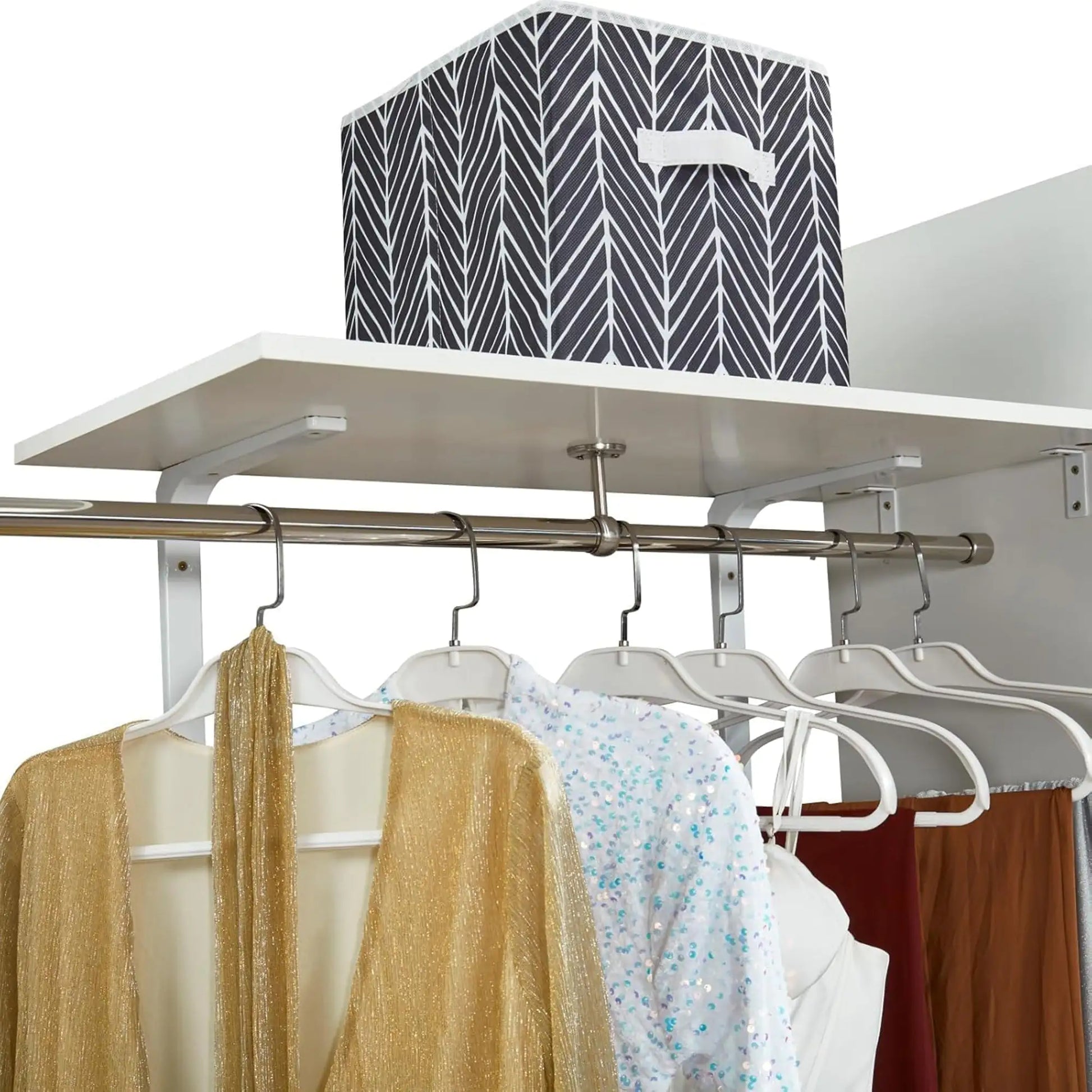 Wall mounted closet organizer white with metal hanging rod and shelf holding clothes and storage bin