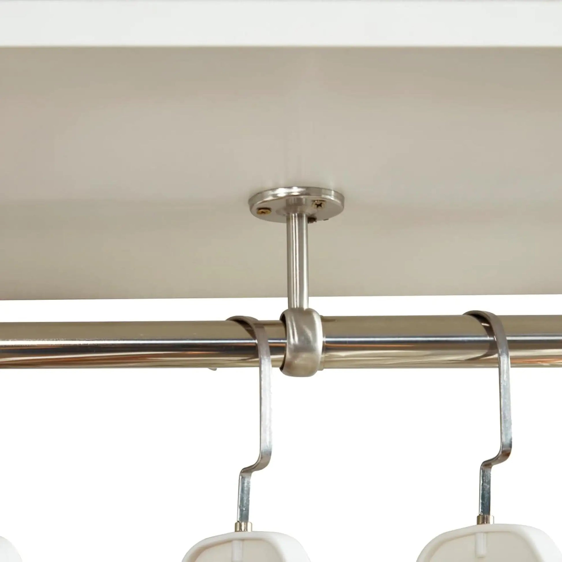 Close-up of metal rod ceiling support for wall mounted closet organizer white showing hanging hooks