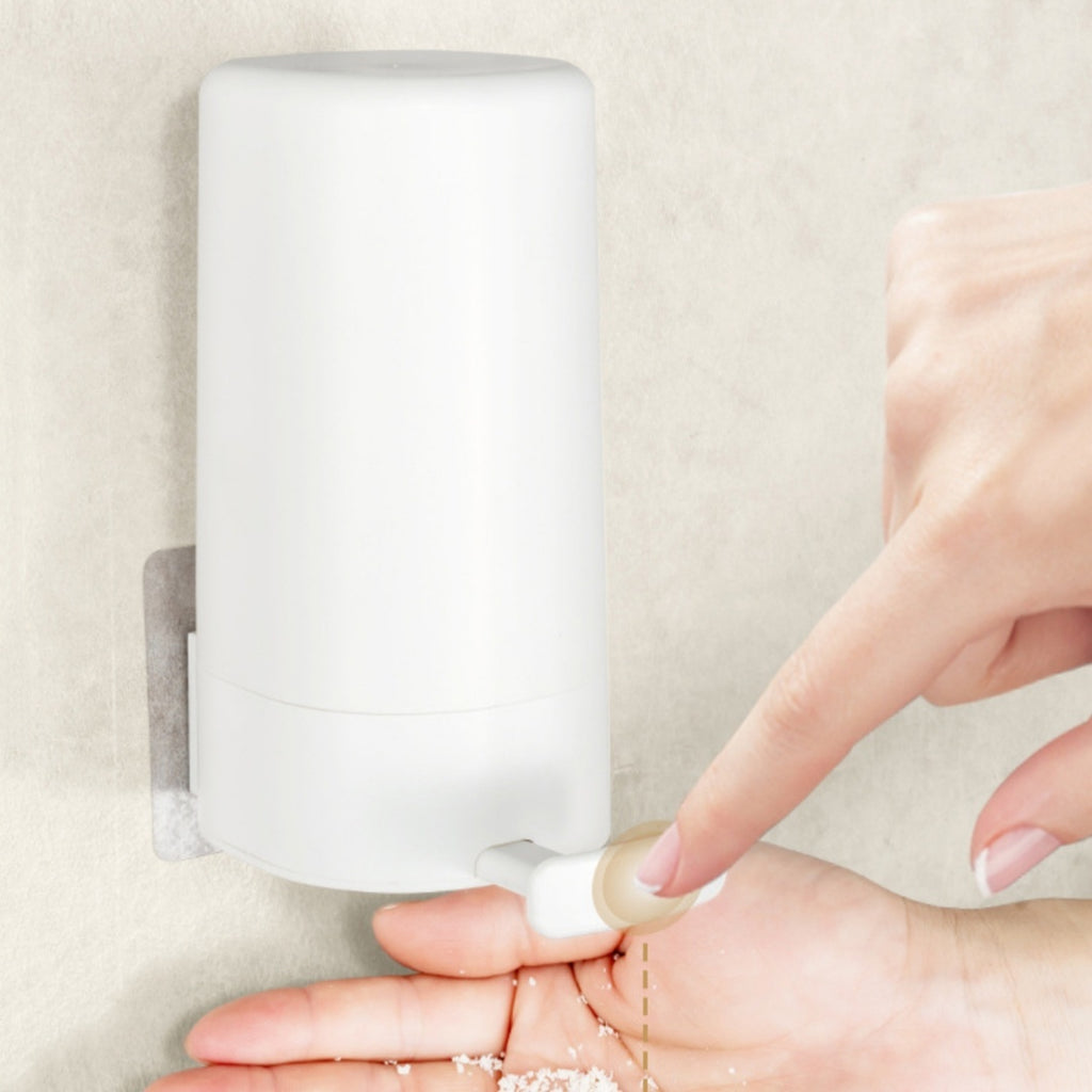 Shopi Vella white wall mounted soap grinder dispenser being used to dispense soap onto hands