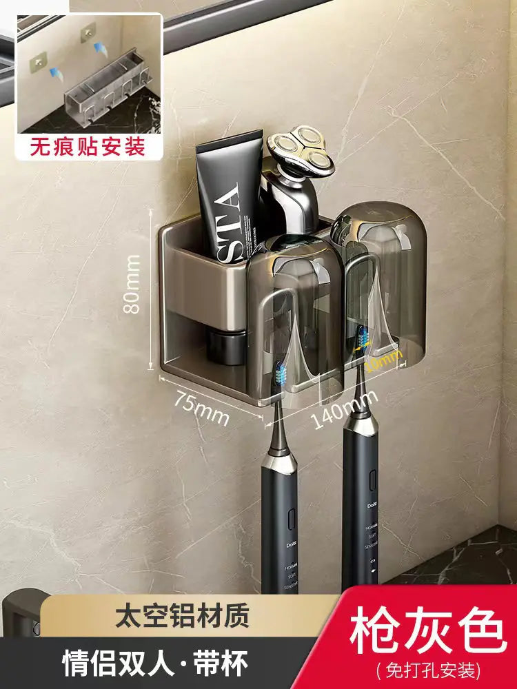 Wall-mounted toothbrush holder in gray with two cups holding electric toothbrushes and a tube on bathroom wall