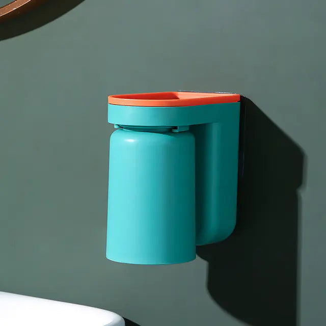 Blue and orange wall-mounted toothbrush holder attached to a green bathroom wall