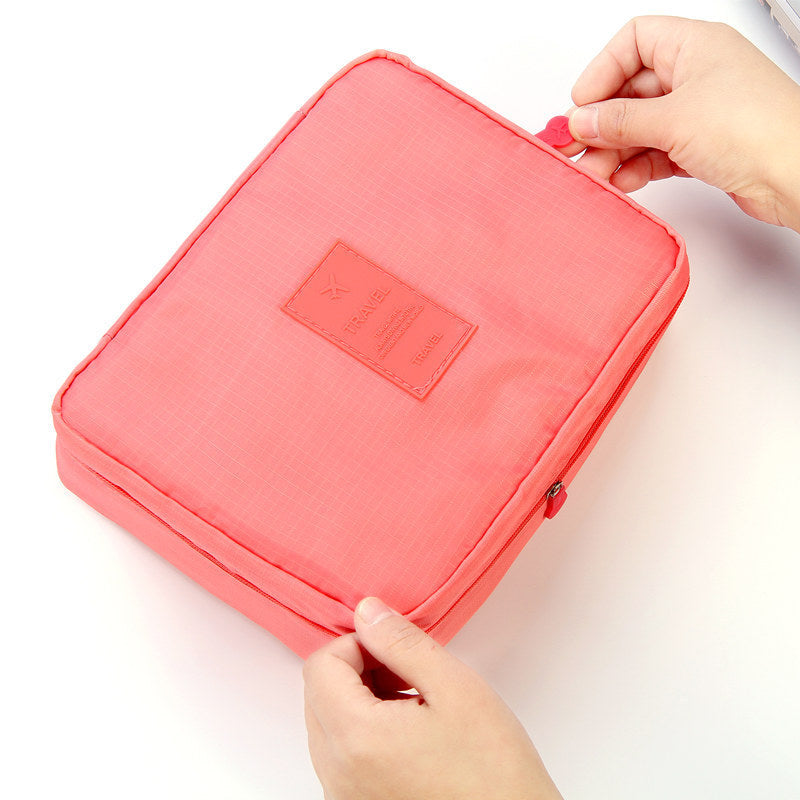 Shopi Vella waterproof cosmetic organizer with pockets in coral pink being held by hands