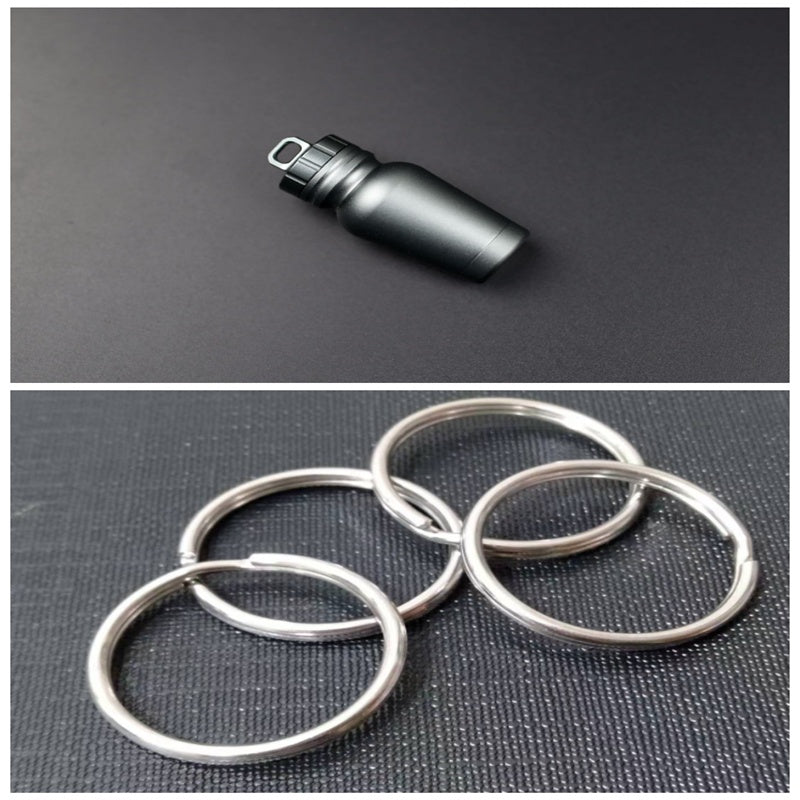 Shopi Vella waterproof medicine bottle for outdoors with black secure cap and four silver key rings on black background