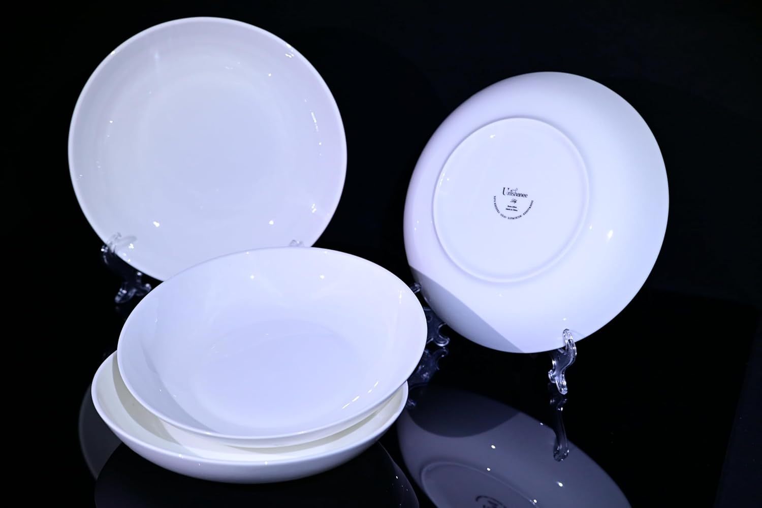Shopi Vella bone china dinnerware set with white elegant plates displayed on black surface