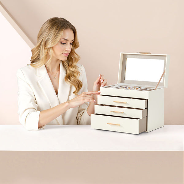 Woman organizing jewelry in a white jewelry storage box with multiple drawers and compartments