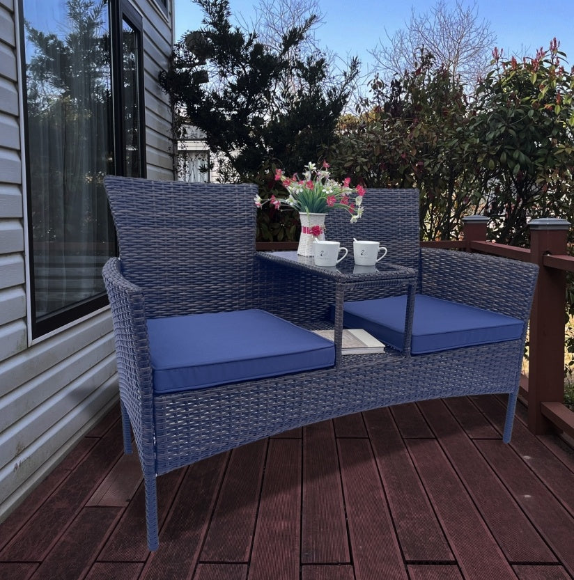 Shopi Vella wicker patio furniture set featuring a blue cushioned loveseat with built-in table and decorative flowers